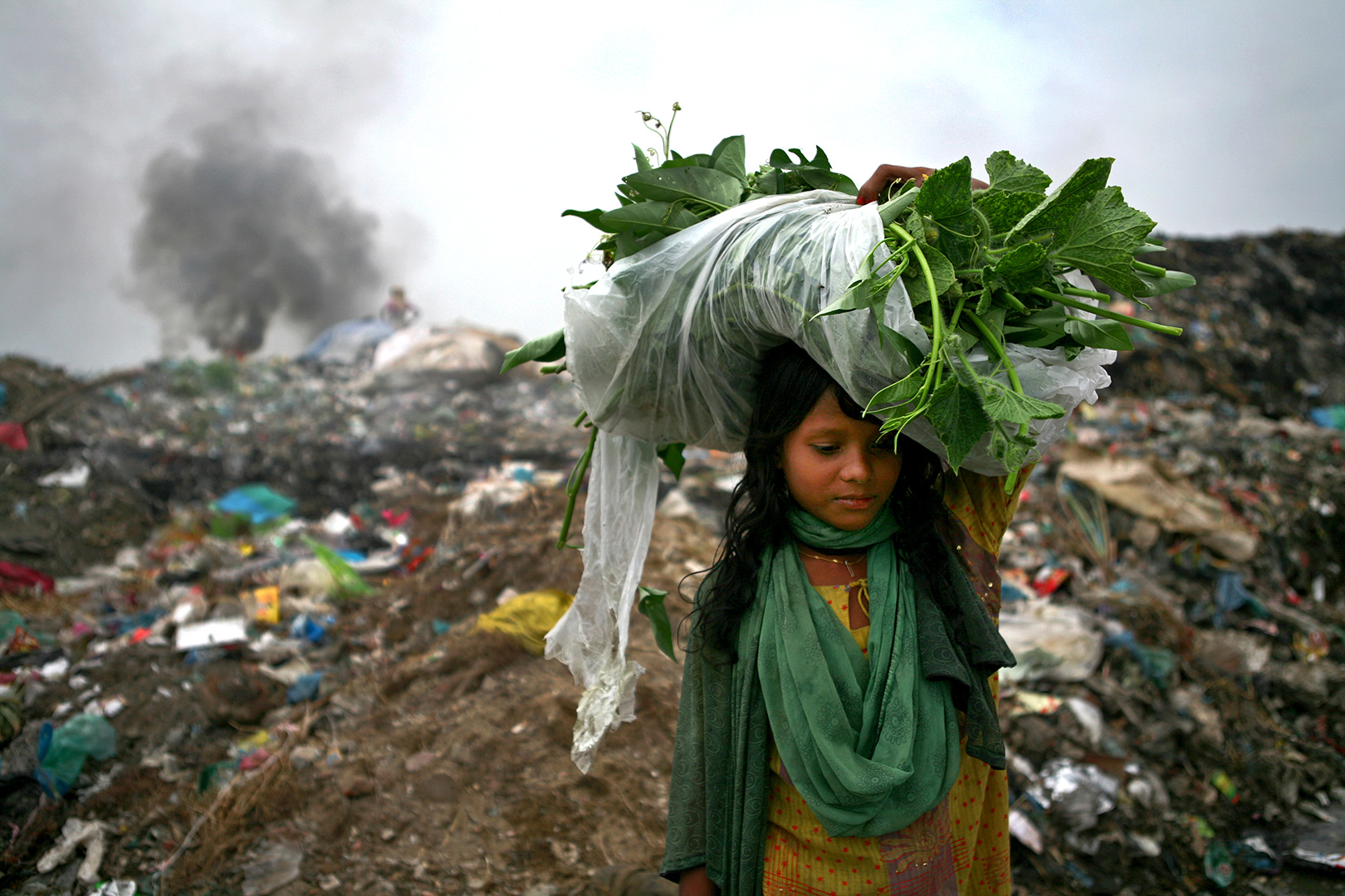 A girl back to home end of day with vegetable, she collected from waste land. The permanent Waste land under Sylhet city corporation. Lalmatia, Sylhet, Bangladesh.