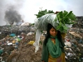A girl back to home end of day with vegetable, she collected from waste land. The permanent Waste land under Sylhet city corporation. Lalmatia, Sylhet, Bangladesh.
